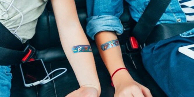 Enfants assis dans une voiture avec des pansements colorés sur les bras
