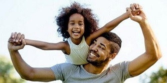 Père portant sa fille sur les épaules
